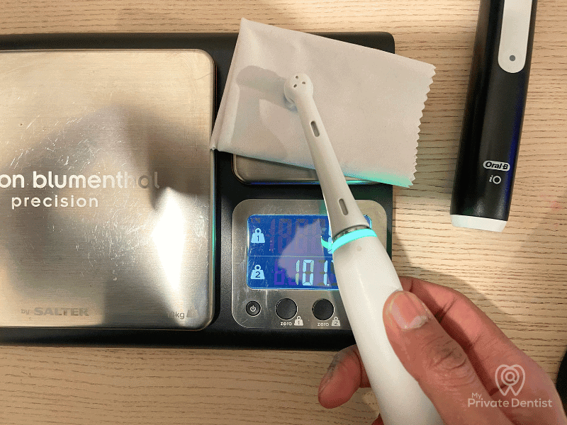 Dentist-testing-the-activation-force-of-an-Oral-B-iO-electric-toothbrush-pressure-sensor-using-a-digital-kitchen-scale